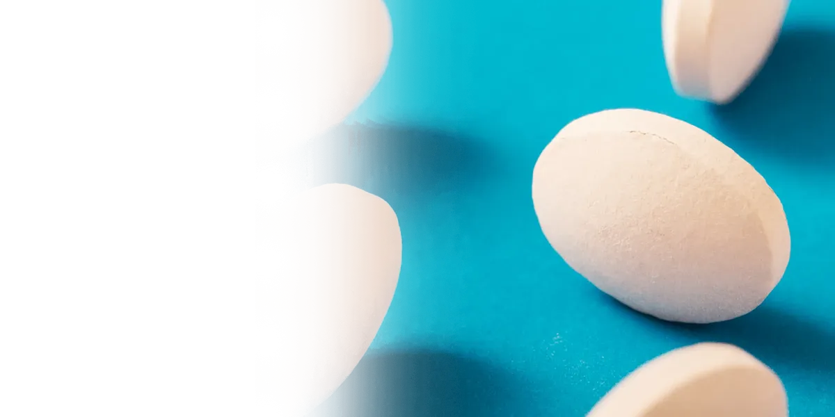 Λευκά δισκία και χάπια σε γαλάζιο φόντο